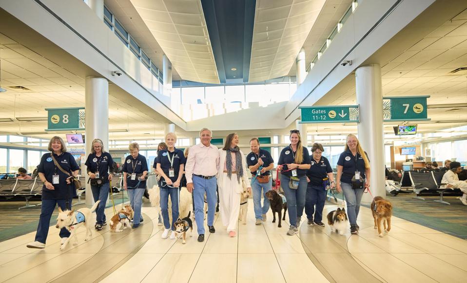 Pup Patrol therapy dogs and handlers walk at Pensacola International Airport.