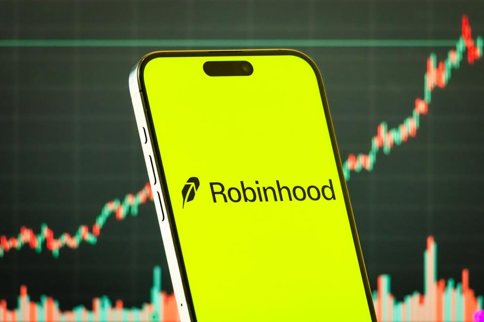 Robinhood Markets Inc. logo on smartphone with stock market chart background