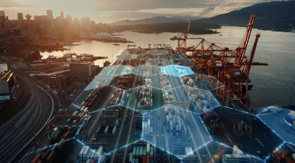 A drone flies above a busy port city.