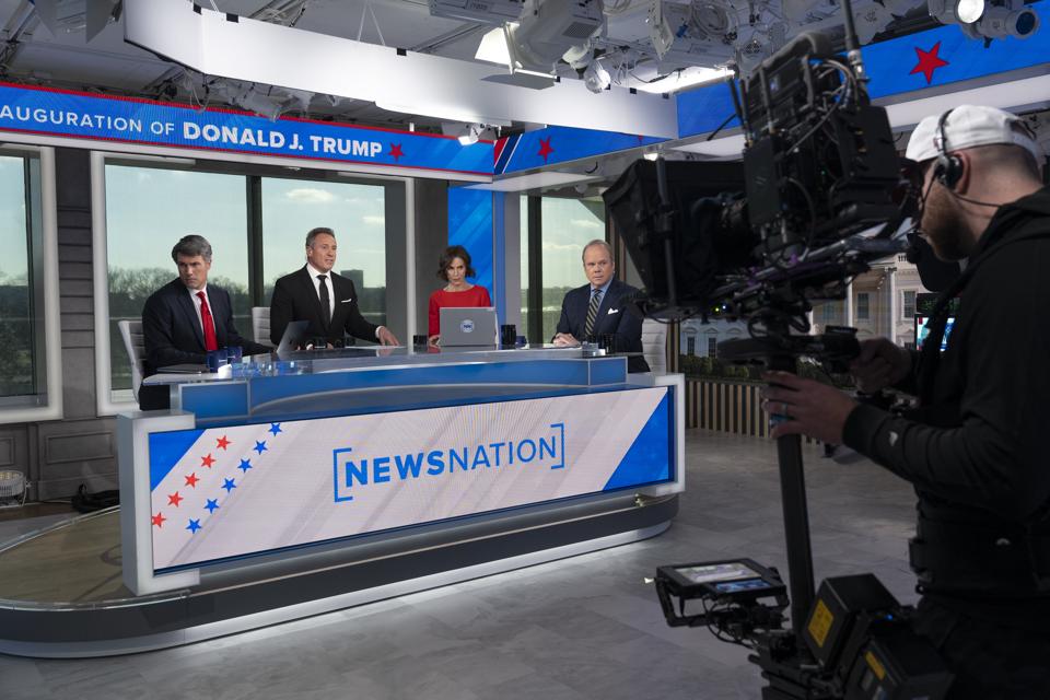 NewsNation anchors behind the network's desk during a broadcast