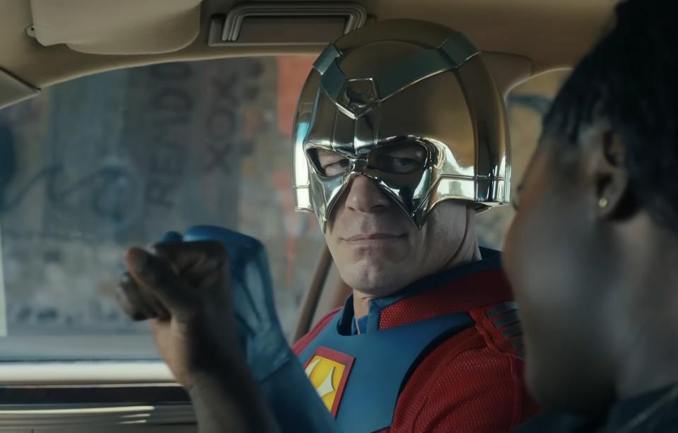a man wearing a silver helmet and a red and blue superhero costume