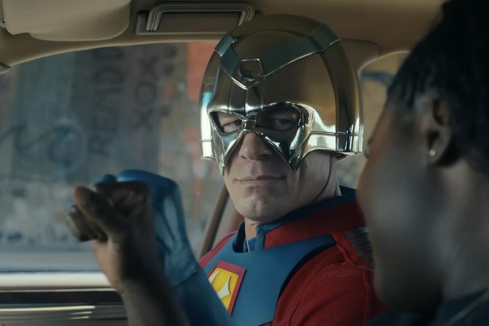 a man wearing a silver helmet and a red and blue superhero costume