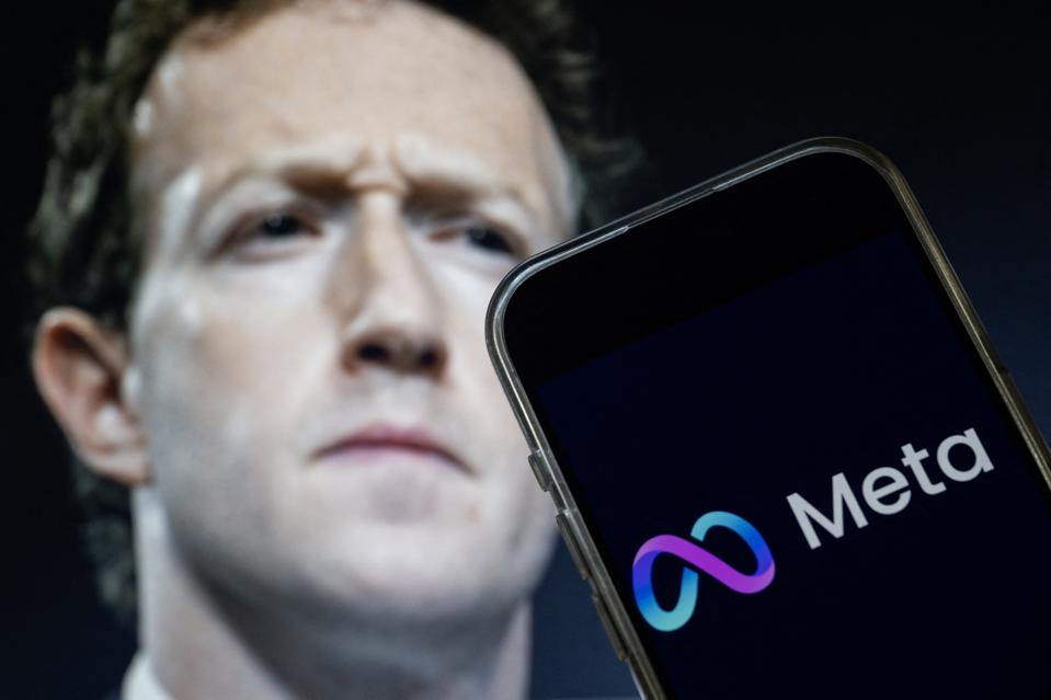 A smartphone displaying the Meta logo in front of a blurred close-up of Mark Zuckerberg’s face, symbolizing scrutiny of Meta’s AI policies.