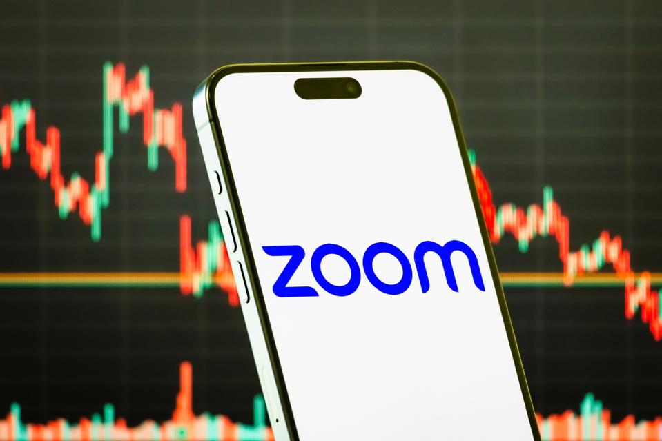 Zoom Video Communications Inc. logo displayed on smartphone with stock market chart background