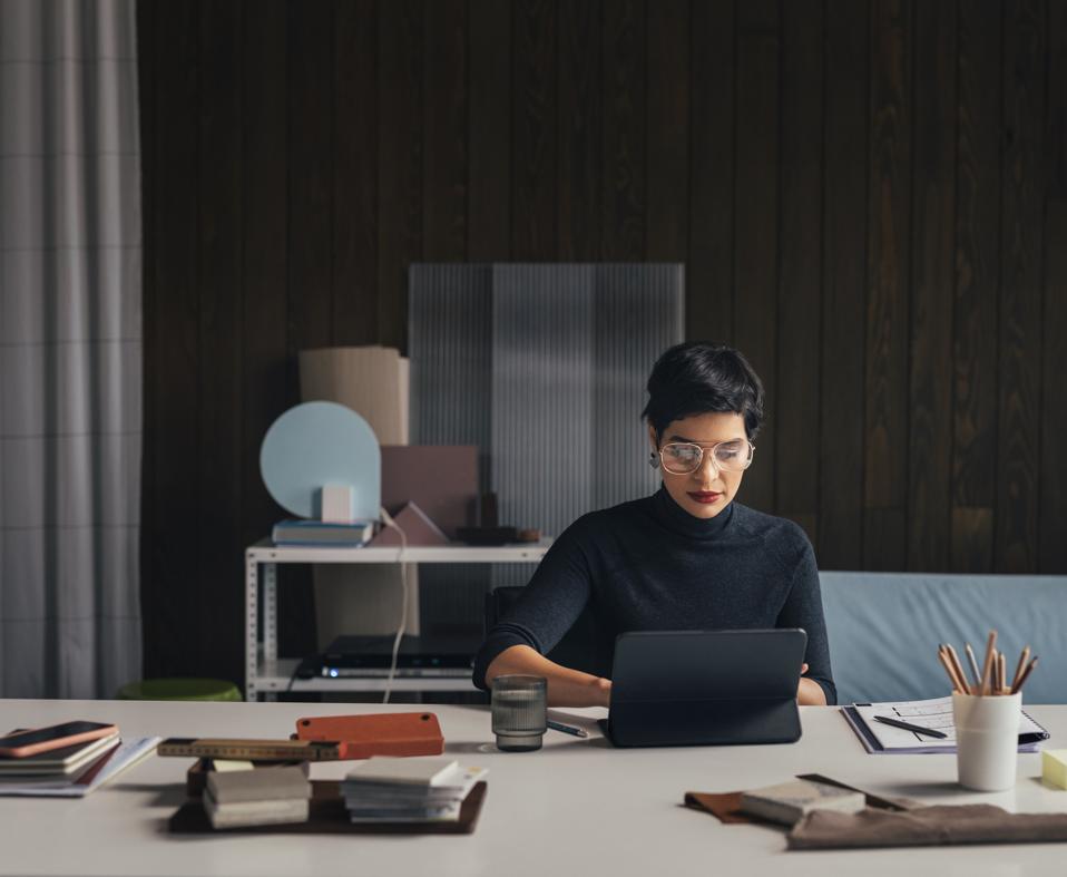 Powerful professional woman working remotely using laptop, in a stylish home office setup