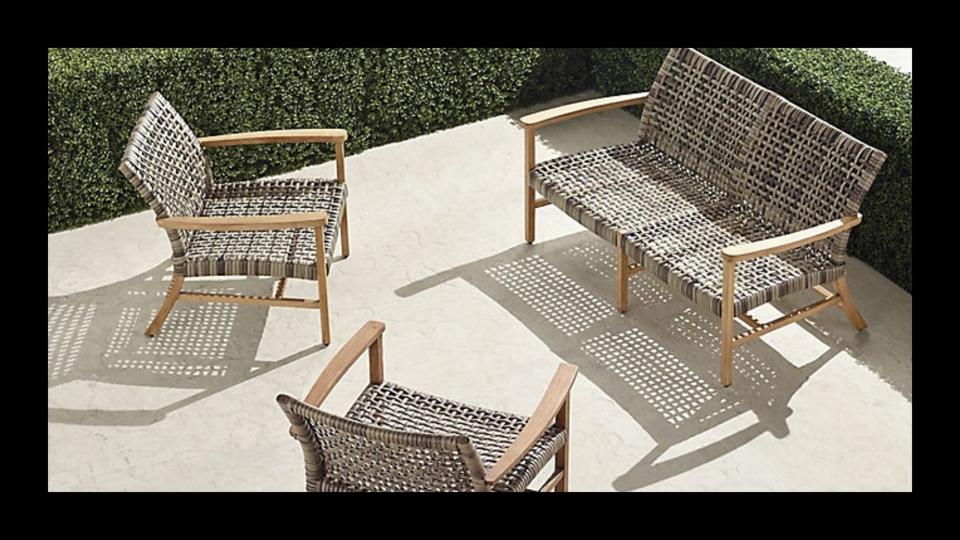Round dining table with four swivel chairs on black background.