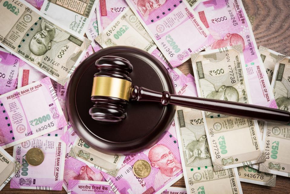 stock photo of Indian Currency Rupee Notes with Law Gavel isolated on white, concept showing indian finance law with paper currency of 500,2000 with gavel and indian flag