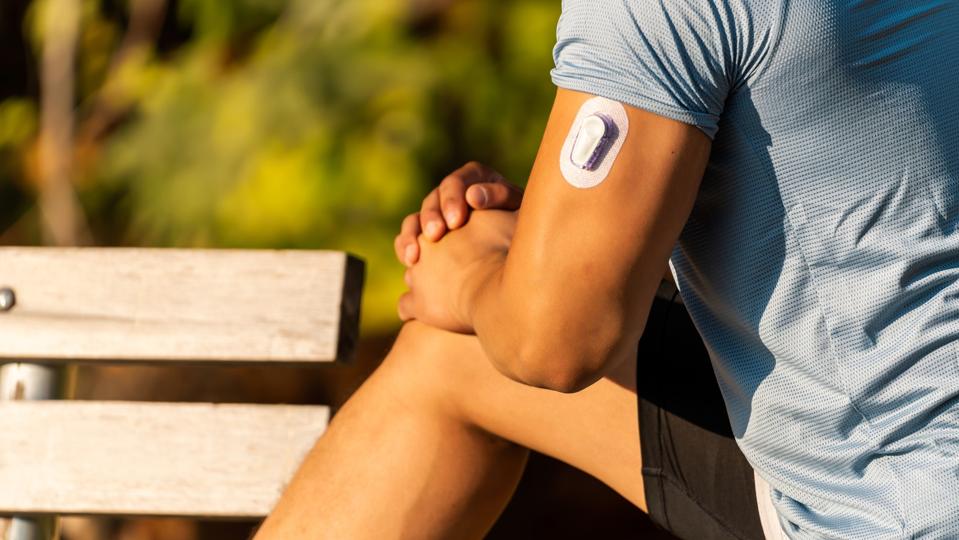 Athlete Stretching with Continuous Glucose Monitor Transmitter