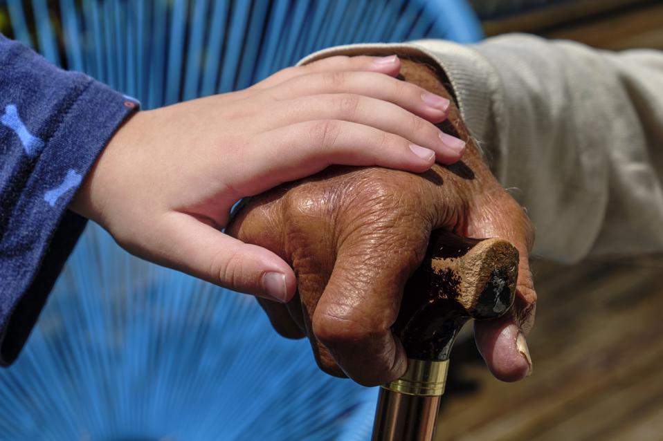 Grandfather and grandson holding hands. Mixed race family.