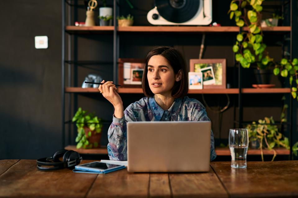 Mid adult businesswoman utilizing laptop and seeing away