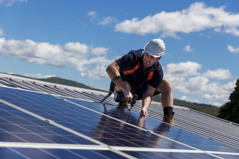 Solar panel installer with drill installing solar panels