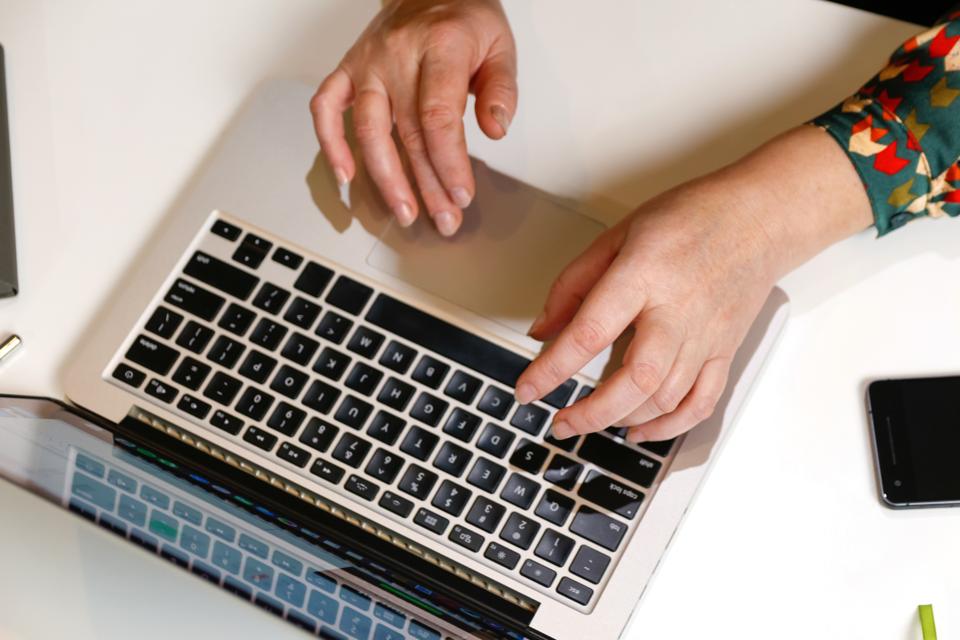 Female hand typing keyboard on laptop. Unrecognizable elegant woman working on computer at office. Start or finish of a work day. Workspace. Top view. Time for work. Close-up, closeup