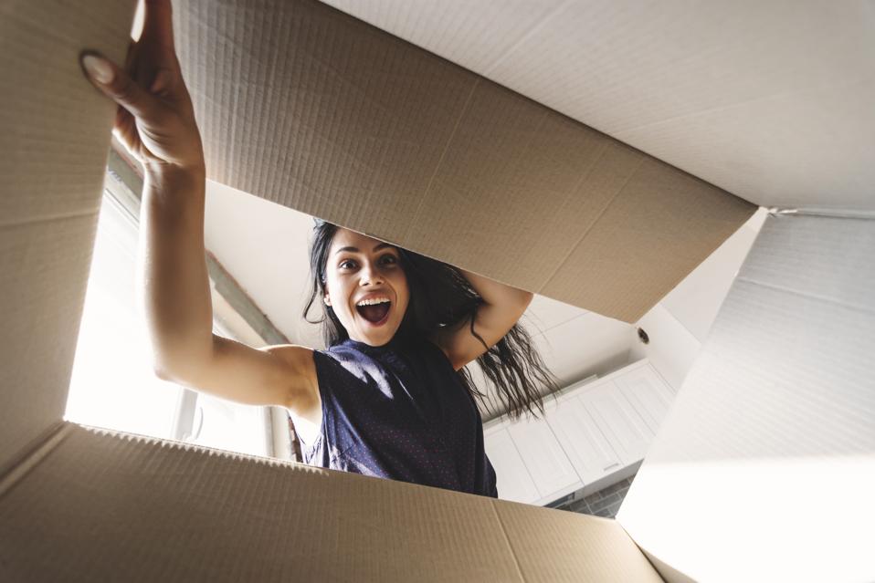 A surprised woman looking into a box, symbolizing the unexpected opportunities that career networking and meetings without purpose can create.