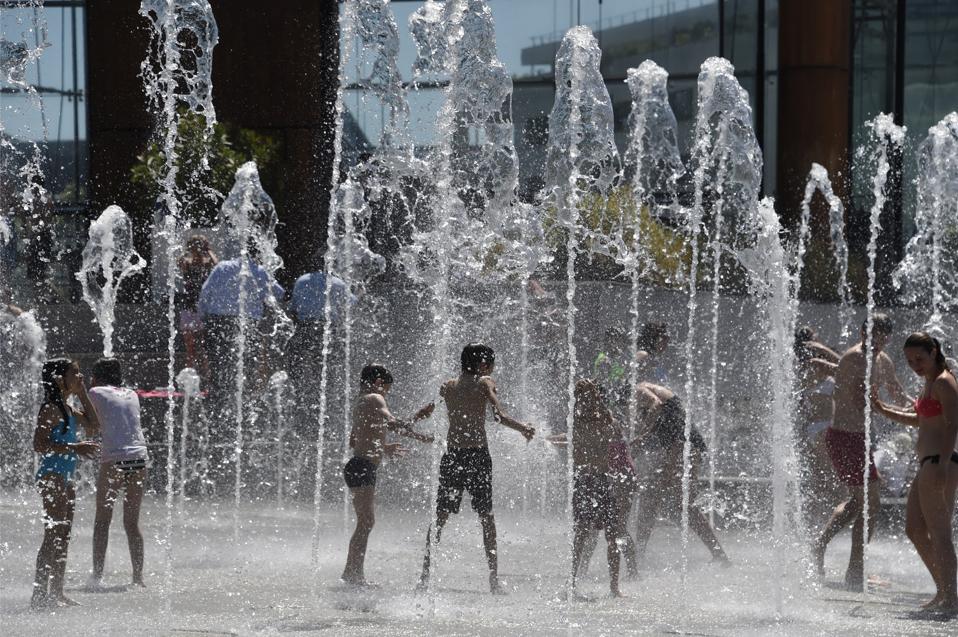 Children play in a public fountain in Paris