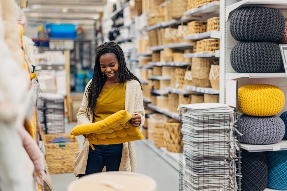 A woman looks at chair cushions in a department store