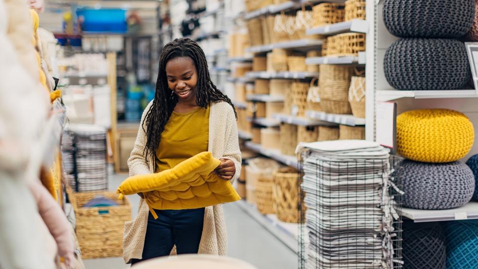 A woman looks at chair cushions in a department store