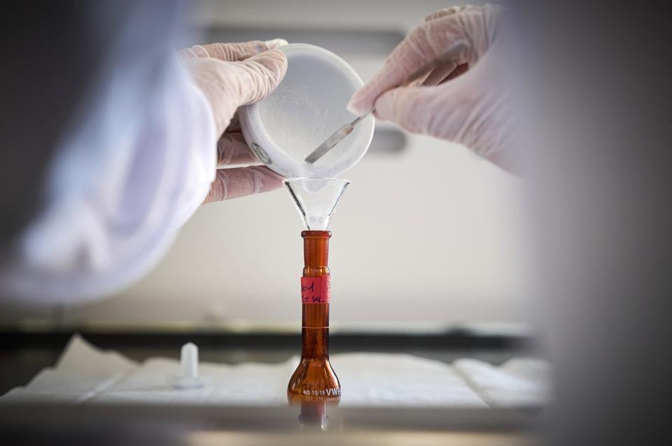 A pharmacist tests a counterfeit drug in a lab.