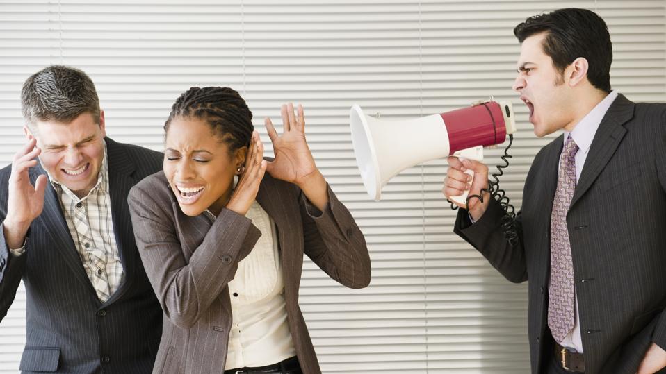 Businessman shouting through bullhorn at co-workers