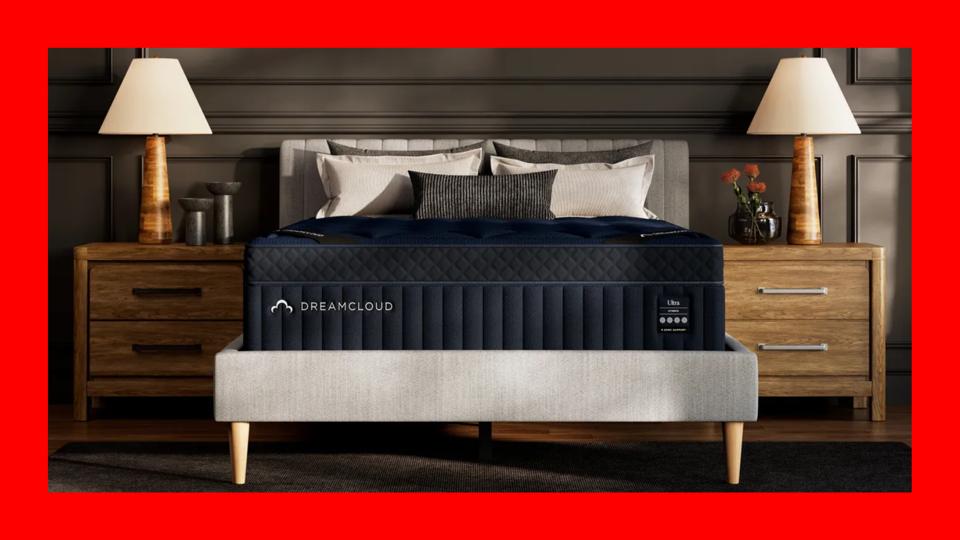 The DreamCloud Ultra Mattress on a gray bed frame with a red border. 