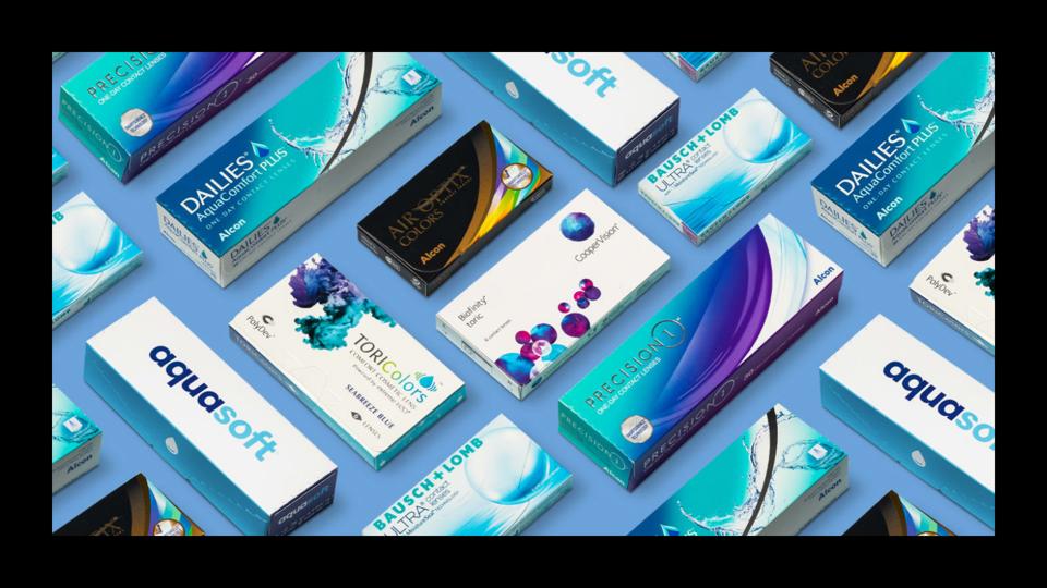 An assortment of contact lens boxes on a blue surfaace