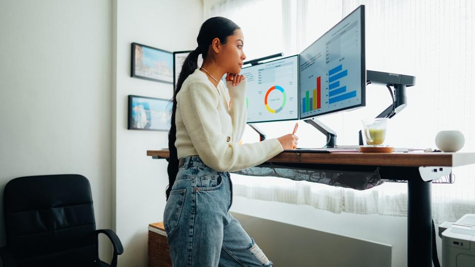 Woman with back pain working at standing desk home office