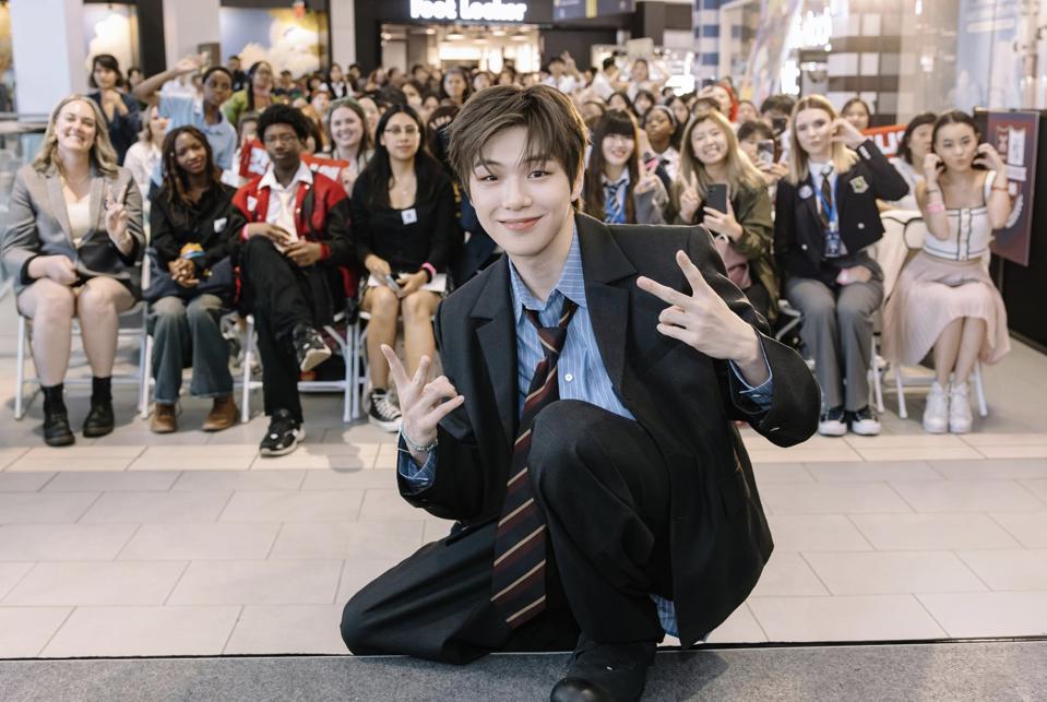 Kang Daniel poses with fans and makes the V sign with both hands.