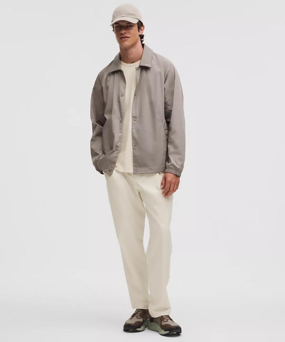 A man wearing white Lululemon Woven Classic-Fit Pleated Trousers