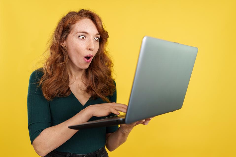 Redheaded woman using a laptop looking at the featured section of a LinkedIn profile