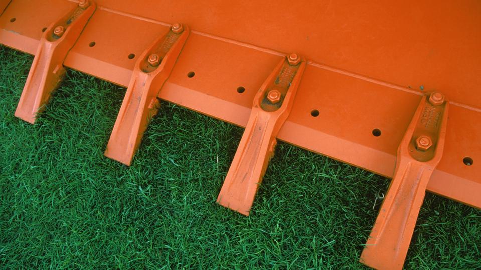 Detail of teeth at front of excavator or loader bucket.