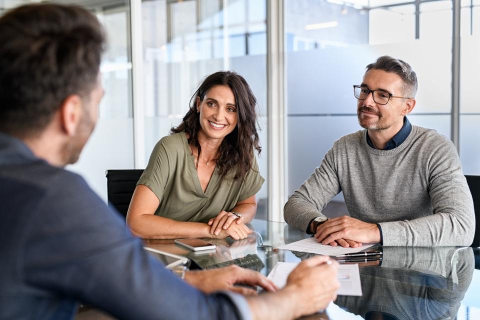 A mature couple meet with a financial planner. 