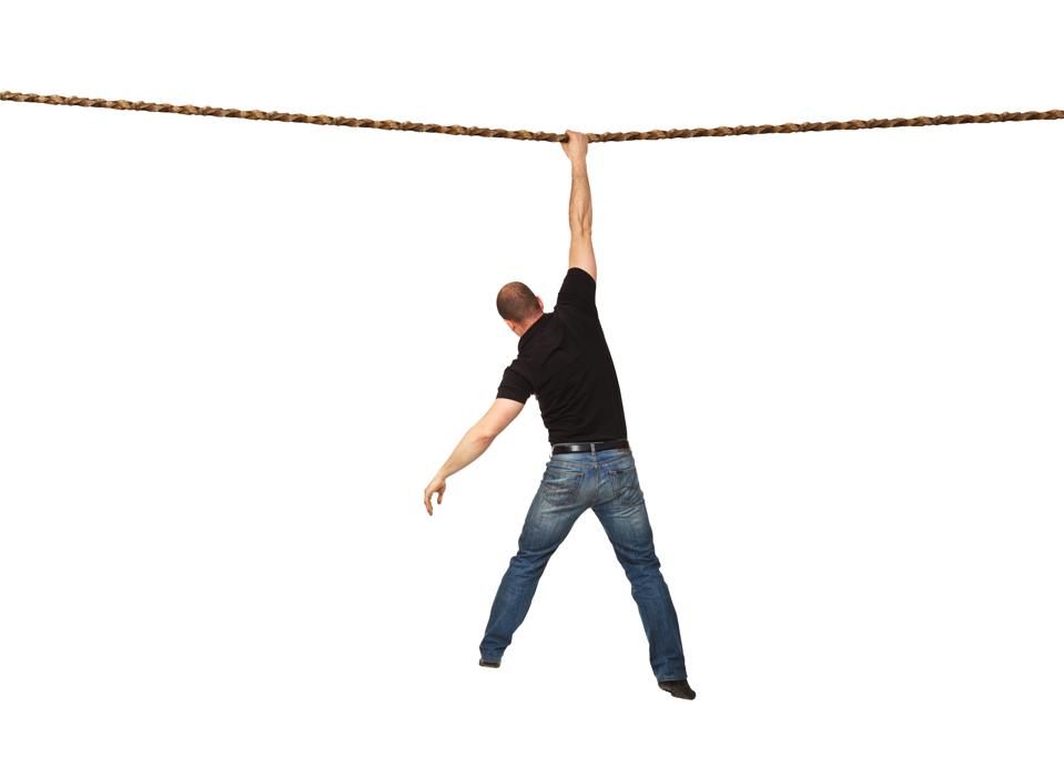 Rear View Of Man Hanging On Rope Against White Background