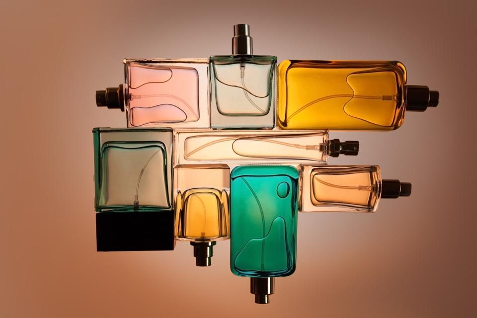 Upper view, straight bed set of bottles perfume on the beige empty background.