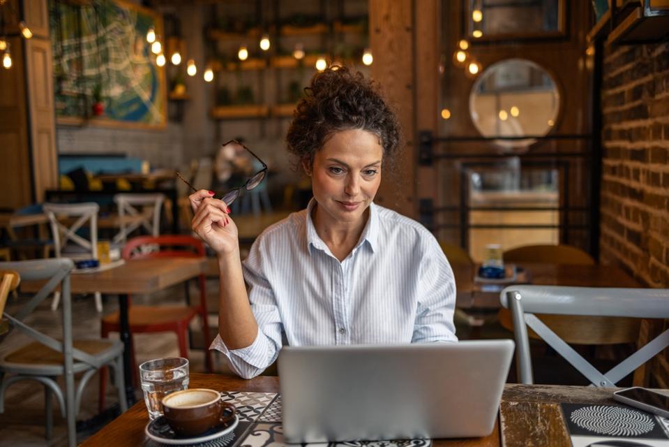 Businesswoman working on laptop in a cafe
