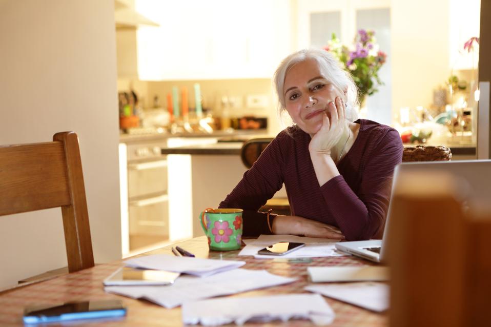 Mujer haciendo finanzas domésticas en la cocina