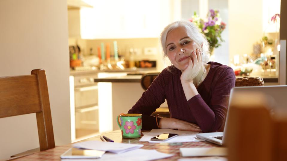 Mujer haciendo finanzas domésticas en la cocina
