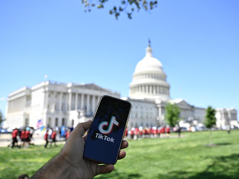 An iPhone featuring TikTok's logo in front of the Capitol building in Washington, DC