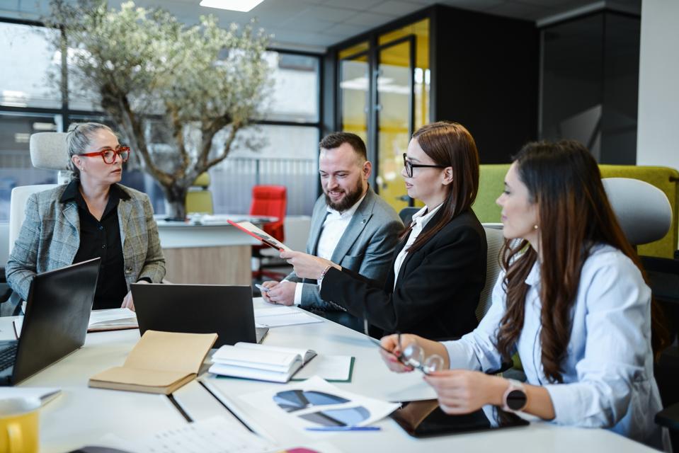 Female Chief Marketing Officer Presenting New Strategy To CEO And Board Of Directors