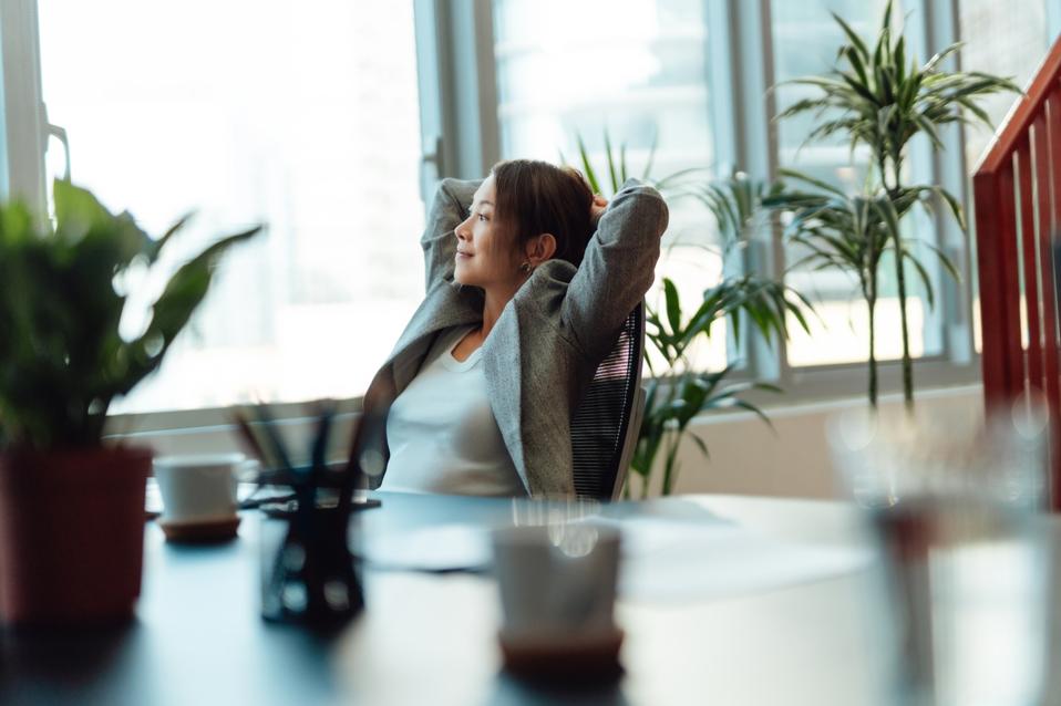 Smiling Asian businesswoman taking a break from work in the office