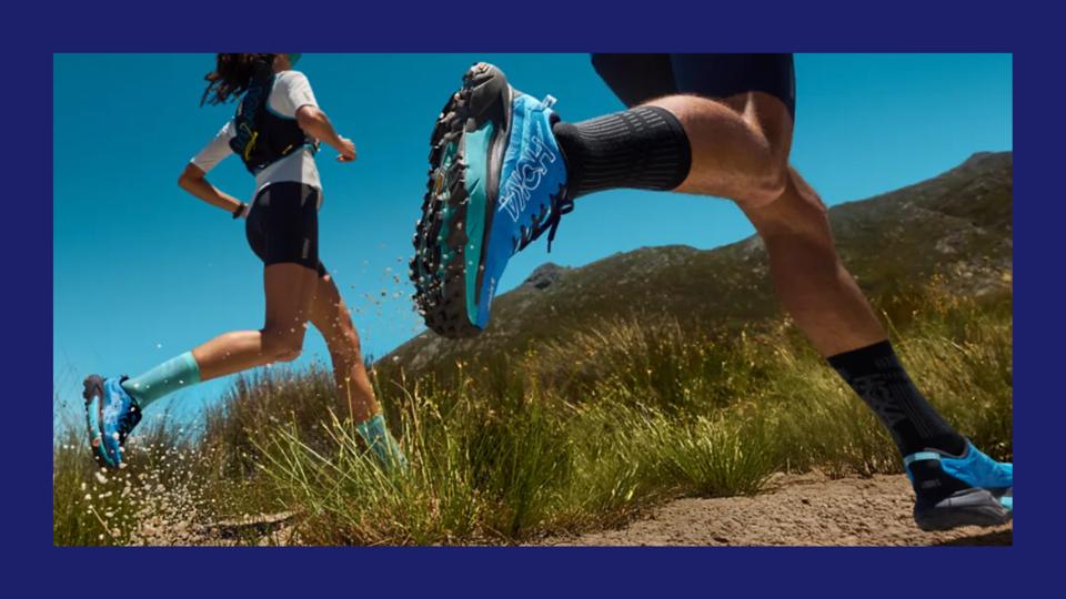 Lifestyle image of two individuals running on a trail wearing Hoka sneakers.