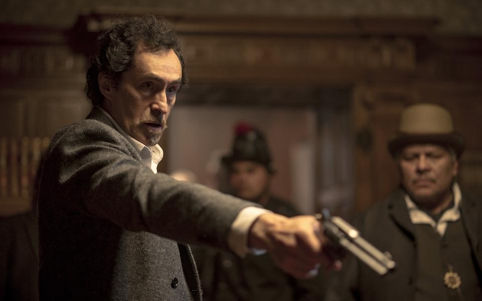 Demian Bichir holding a gun in a scene from "El Dentista."