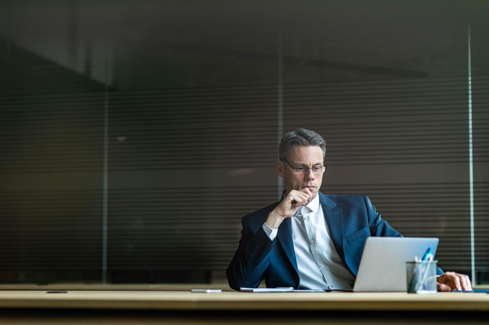 Serious businessman working on laptop in the office.