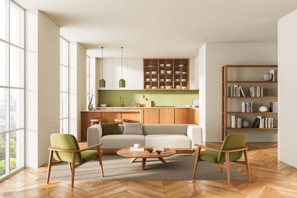 Modern open living room and kitchen interior with green accents, wooden furniture, and natural lighting in cozy minimalist Scandinavian design concept. 3D Rendering