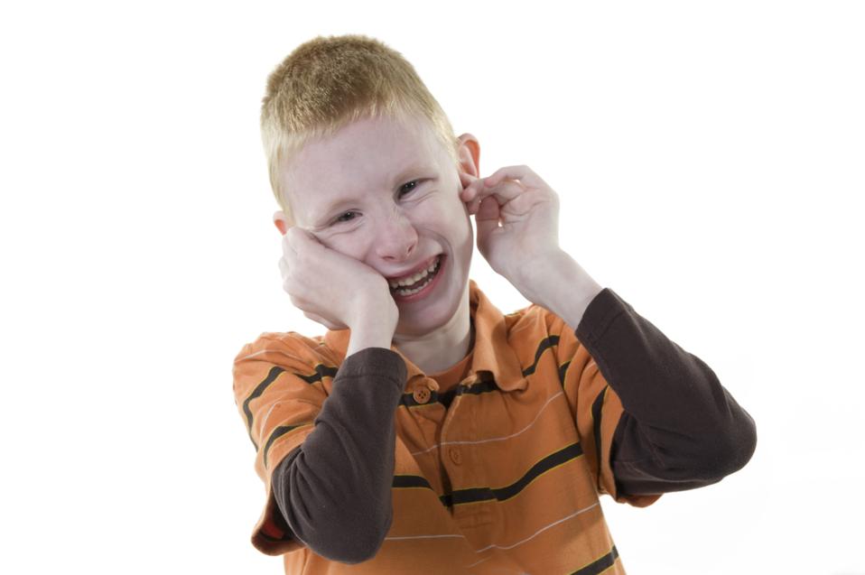 A boy with autism smiling at the camera