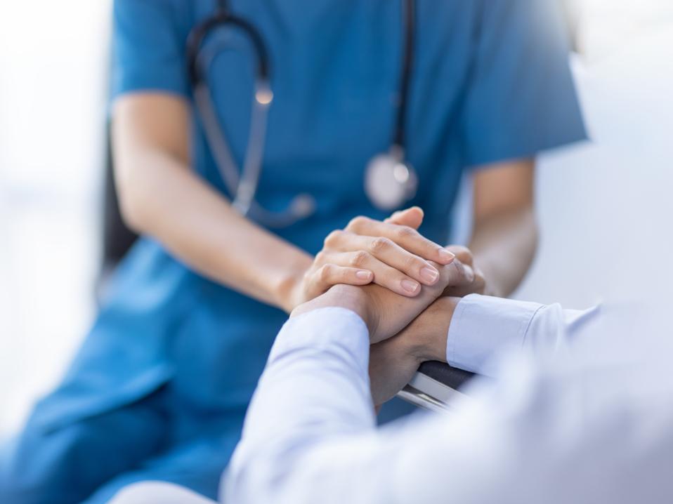 Cropped shot of a female nurse hold her senior patient's hand. Giving Support. Doctor helping old patient with Alzheimer's disease. Female carer holding hands of senior man