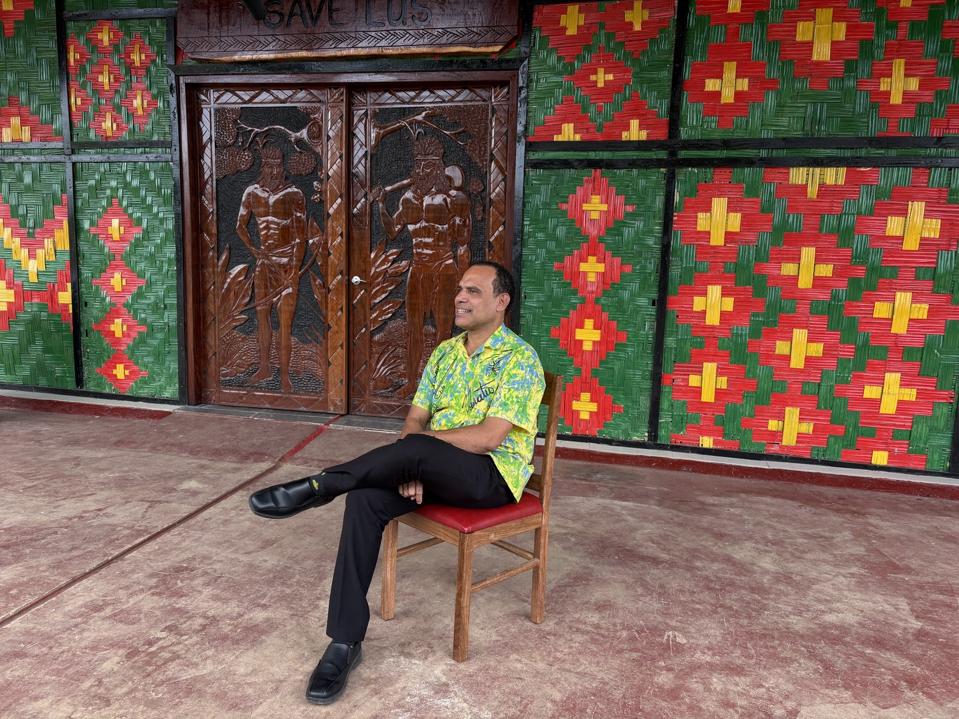 Minister sitting on a chair smiling