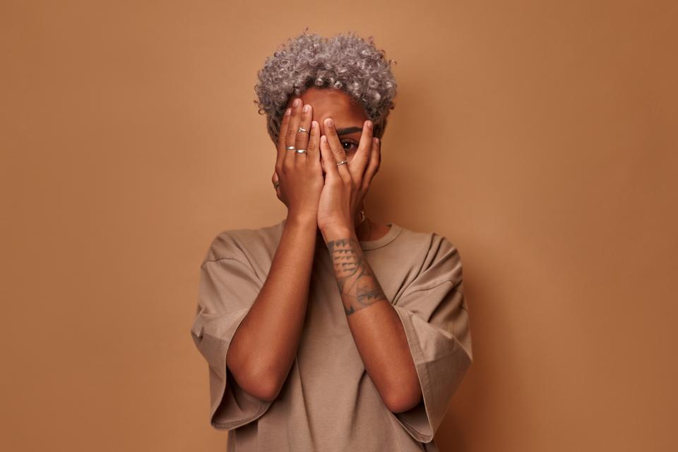 Finding Yourself In The Inquiries You Ask 3 Frightened dark skinned woman covers face with palms peeks through fingers