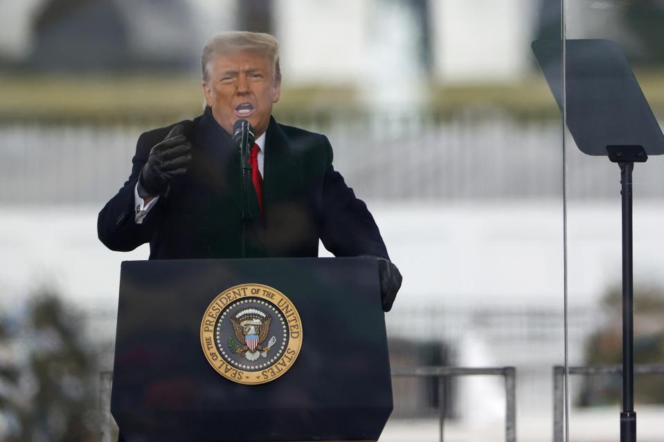 President Donald Trump speaks at a lectern bearing the presidential seal