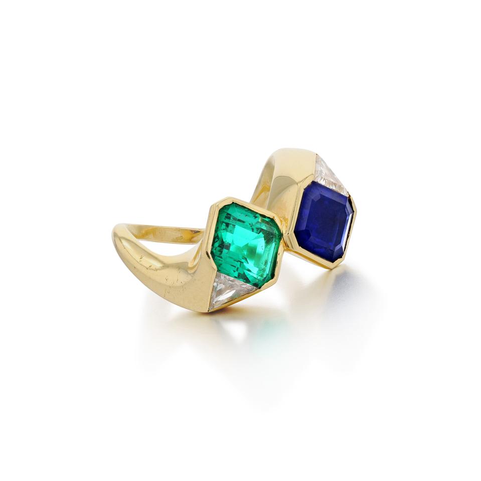 Toi et Moi ring set with a step-cut emerald and sapphire flanked by triagular diamonds