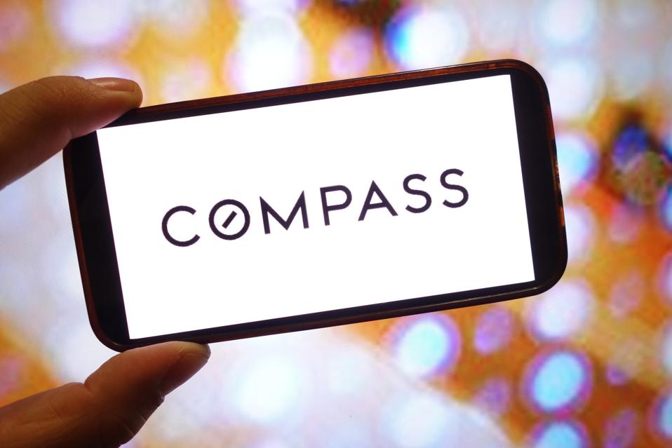 In this photo illustration, a Compass company logo is seen...