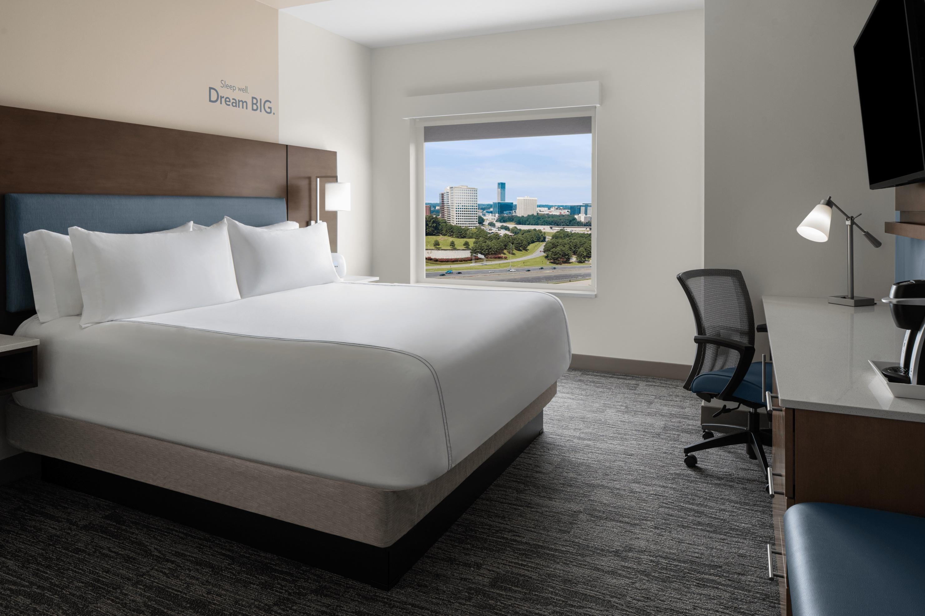 EVEN Atlanta Cobb Galleria bed, desk and rolling chair in room.